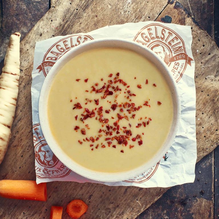 Un bol de soupe à côté des carottes.
