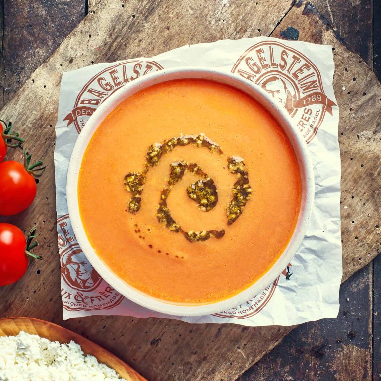 Un bol de soupe aux tomates sur une table en bois.