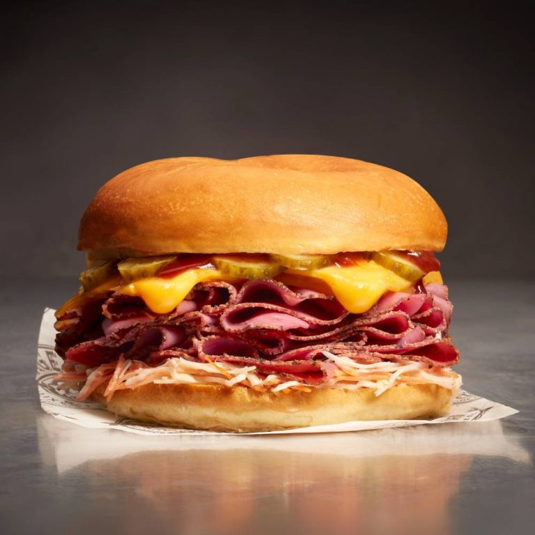 Un sandwich avec de la viande et du fromage sur un morceau de papier.