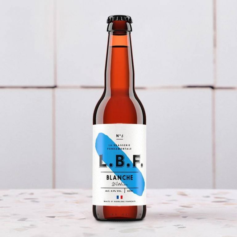 Une bouteille de bière blanche sur une surface carrelée avec une étiquette simple.